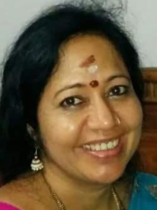 Dr. Gayatthri Sri Sri smiling, wearing a pink and teal saree
